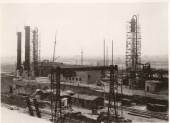 “Picture 3 shows, at left, three columns that have been positioned, with the assembly  towers already removed […] At right in the picture, a scaffolded column is visible, with a number of pipes already installed. The light-colored part, about 3/4 of the way up, is the insulation [...] About 1 m above the planks of the actual work platforms, handrails have been attached so that work can be done on these platforms without belts, but in an accident-proof way.”'(Photo 1943/44, description by I.G. Farben defense counsel, Wollheim lawsuit, 1955)'© Central State Archive of Hesse (records of Wollheim lawsuit)